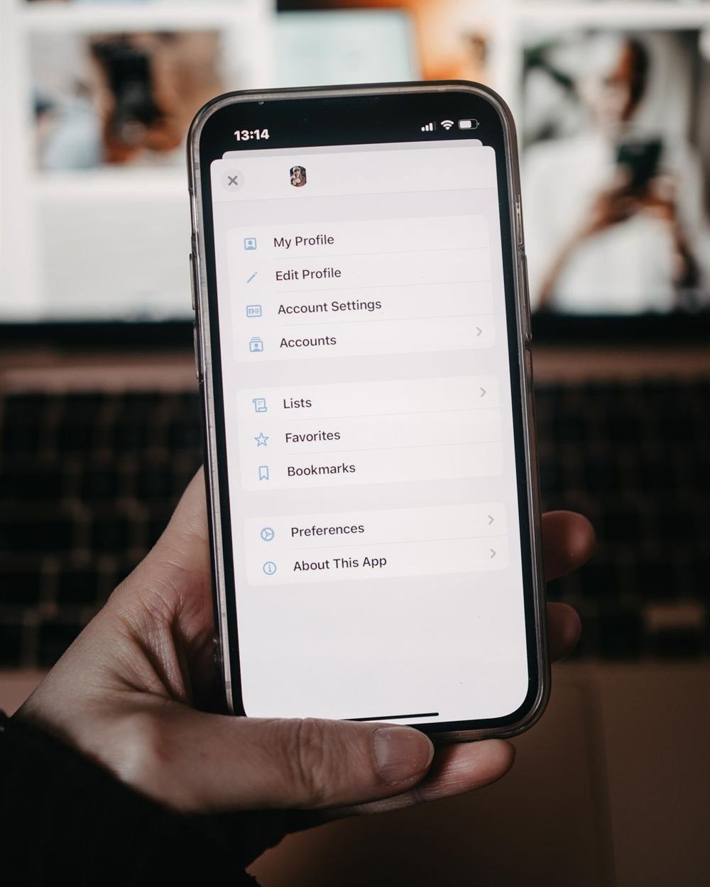 A hand holding a phone that shows a settings menu