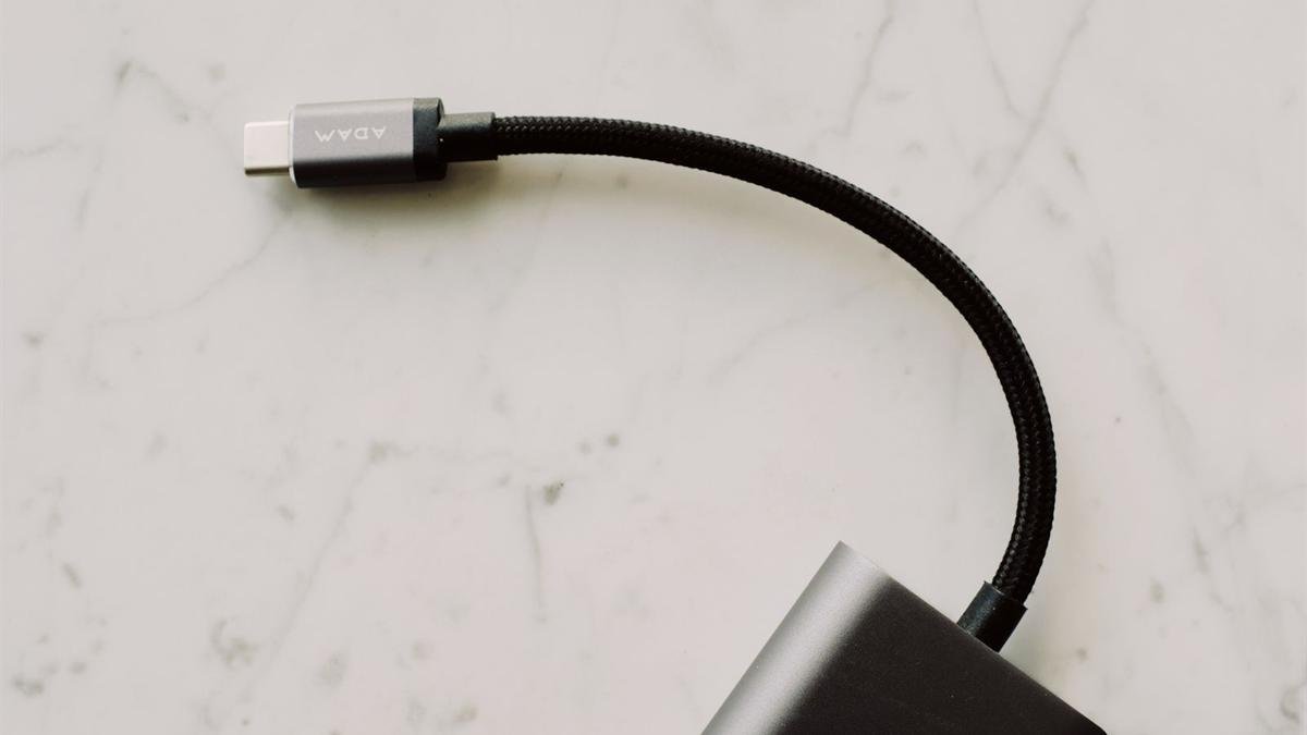A braided black USB-C cable on a white marble surface