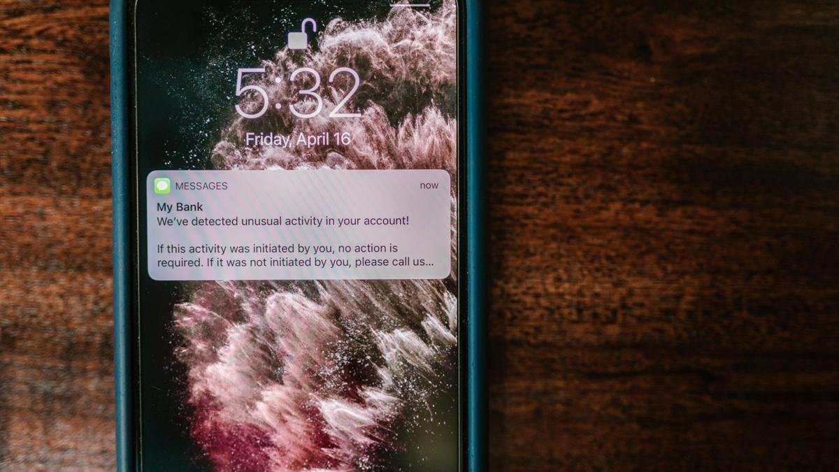A phone lock screen showing a message that claims to be a bank alert about unusual activity