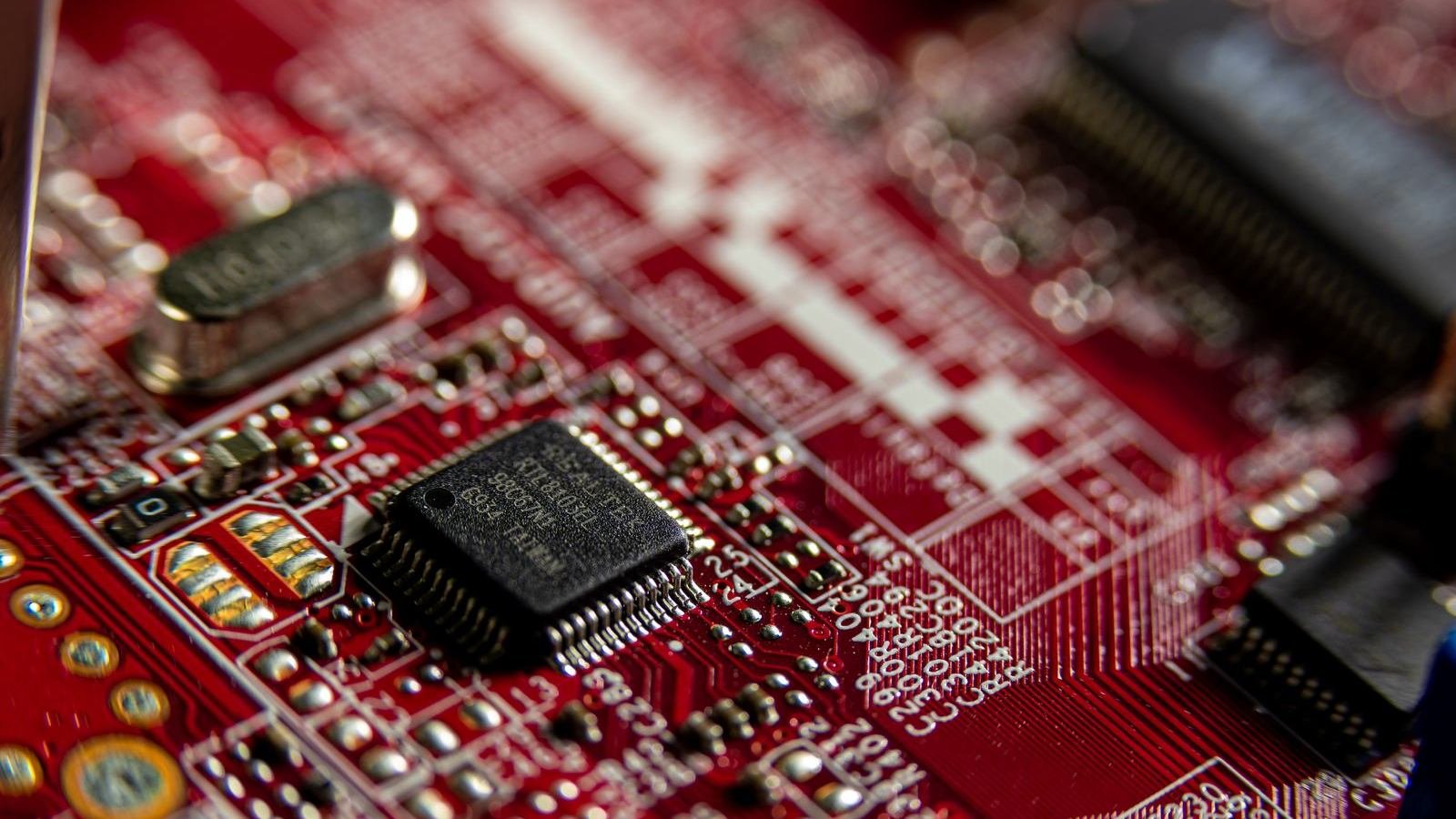 Close-up of a red circuit board with tiny chips